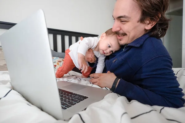 Man trying to work via laptop at home during quarantine with infant baby . Family life during self isolation. Stay home. Work from home, home office — Stock Photo, Image