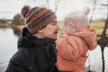 Baba küçük kızını kucaklıyor, sarılıyor, oynuyor, öpüşüyor. Aileyle dışarıda vakit geçirmek. Yaşam biçimi