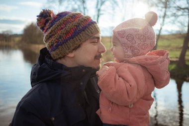 Baba küçük kızını kucaklıyor, sarılıyor, oynuyor, öpüşüyor. Aileyle dışarıda vakit geçirmek. Yaşam biçimi