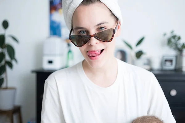 Obraz pięknej kobiety z ręcznikiem na głowie w okularach przeciwsłonecznych na czacie i robieniu zdjęć przez telefon komórkowy. Poranna rutynowa koncepcja. — Zdjęcie stockowe