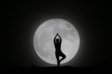 silhouette of a yogi with the moon clipart