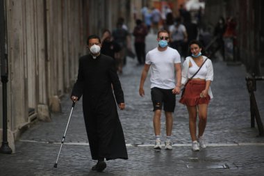 Roma, İtalya 9 Mayıs 2020: Maskeli bir rahip Roma sokaklarında yürüyor. Covid-19 acil karantinasından sonra İtalya 'da ikinci aşamaya başlayan ilk hafta sonu..