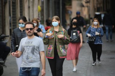 Roma, İtalya 9 Mayıs 2020: Maskeli insanlar Roma sokaklarında yürüyor. Covid-19 acil karantinasından sonra İtalya 'da ikinci aşamaya başlayan ilk hafta sonu..