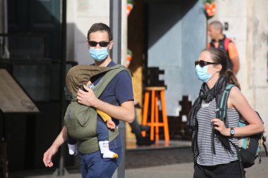Roma, İtalya 9 Mayıs 2020: Roma 'da Campo dei Fiori' de maskeli İtalyan aile ve bebek yürüyor.. Covid-19 acil karantinasından sonra İtalya 'da ikinci aşamaya başlayan ilk hafta sonu..