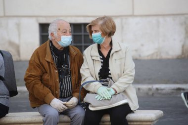 Roma, İtalya 9 Mayıs 2020: Maskeli yaşlılar Roma 'daki Piazza Navona' da dinleniyor. Covid-19 acil karantinasından sonra İtalya 'da ikinci aşamaya başlayan ilk hafta sonu..