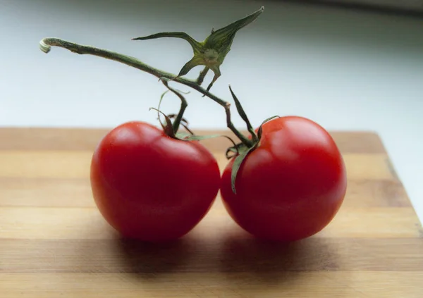 Rijpe rode tomaten op het houten bureau — Stockfoto