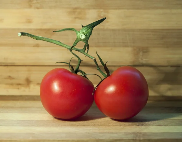 Rijpe rode tomaten op het houten bureau — Stockfoto