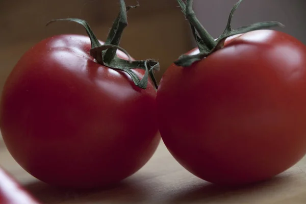 Rijpe rode tomaten op het houten bureau — Stockfoto