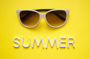 Sarı arka plan ve metin yaz üzerinde güneş gözlüğü. Üstten görünüm. Tatil ve tatil kavramı