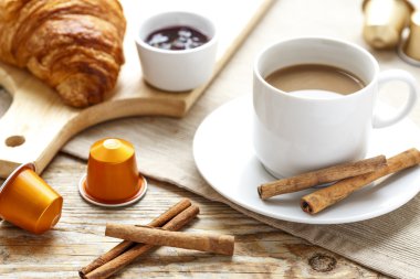 Kahve, kraker ve ahşap masa üzerinde kruvasan kahvaltı