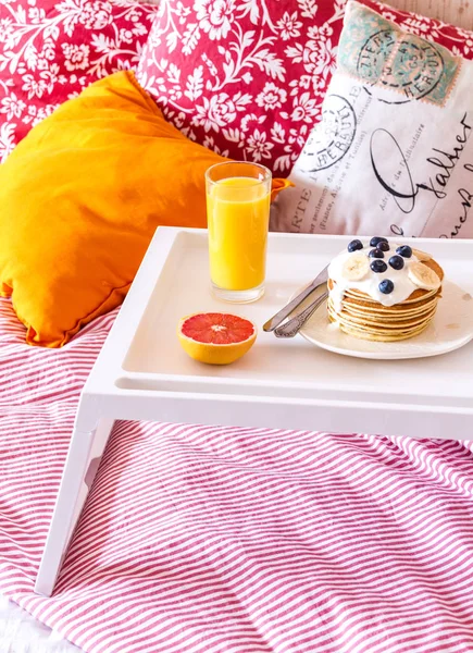 Konzept des Frühstücks im Bett auf Tablett mit Saft — Stockfoto