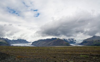 Güzel dağlar ve İzlanda'daki yol boyunca dramatik gökyüzü
