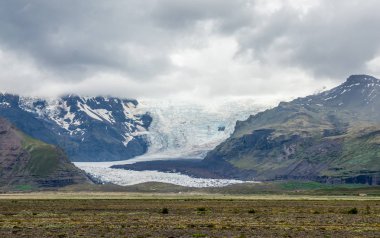 Güzel dağlar ve İzlanda'daki yol boyunca dramatik gökyüzü