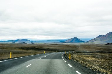 Güzel dağlar ve İzlanda'daki yol boyunca dramatik gökyüzü