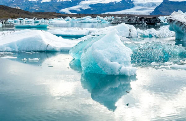 Laguna glacial en Islandia, clima nublado, montañas en el horizonte. El lago glacial refleja el cielo —  Fotos de Stock