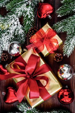 Ahşap arkaplan görünümünde köknar dalları olan hediye kutuları