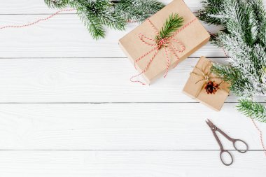 Ahşap arkaplan görünümünde köknar dalları olan hediye kutuları