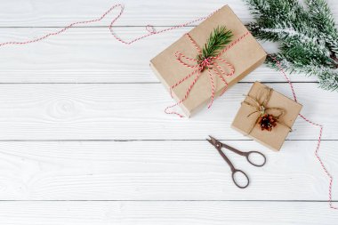 Ahşap arkaplan görünümünde köknar dalları olan hediye kutuları