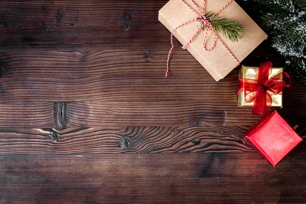 Packaging christmas gifts in boxes on wooden background top view — Stock Photo, Image