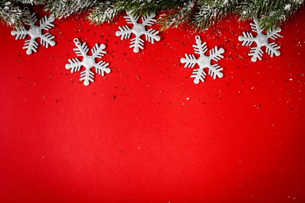 Giocattoli di Natale e rami di abete rosso su sfondo rosso vista dall'alto — Foto Stock