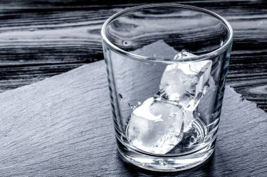 koyu ahşap arka plan üzerinde buz ile boş bardak