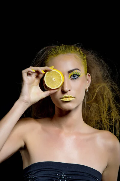 Meisje met gele haren en citroen — Stockfoto
