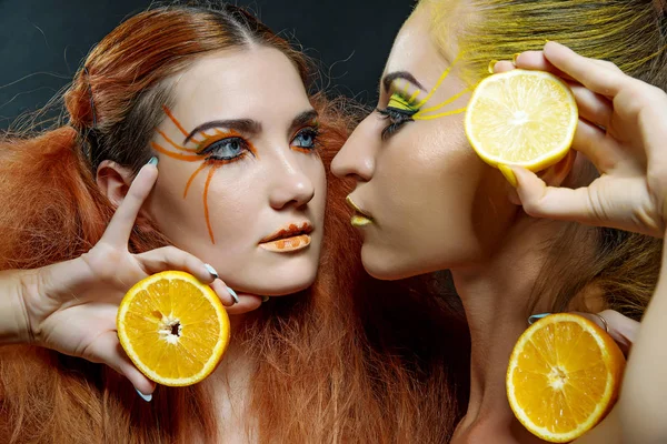 Meisjes met sinaasappel en citroen — Stockfoto