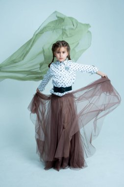 Gri arkaplanda fotoğraf stüdyosunda dinamik kız portresi 