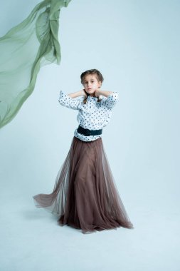 Gri arkaplanda fotoğraf stüdyosunda dinamik kız portresi 