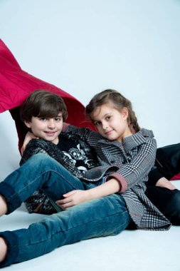 Çocuklar fotoğraf stüdyosunda gri arka planda poz veriyorlar