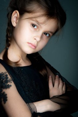 Gri arka planda stüdyo resmi olan güzel bir kız.