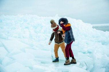 Çocuklar kar üzerinde kış buzunda oynuyorlar.