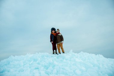 Çocuklar kar üzerinde kış buzunun üzerinde duruyorlar.