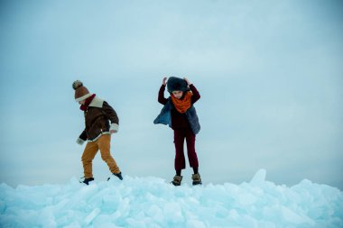 Çocuklar kar üzerinde kış buzunun üzerinde duruyorlar.