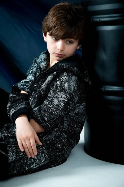 Brunet Enfant Garçon Assis Avec Baril Noir Sur Fond Gris — Photo