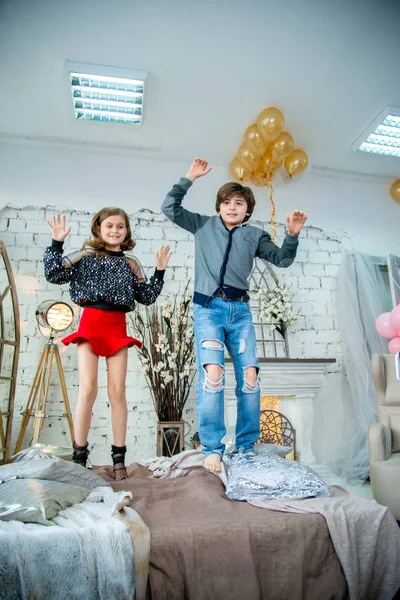Dekor Fotoğraf Stüdyosunda Sarı Balonlarla Yatağa Atlayan Sevimli Çocuklar — Stok fotoğraf