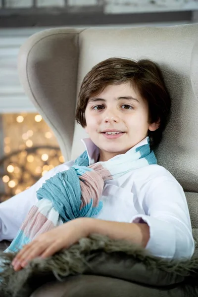 smiling boy sitting on sofa on Christmas background