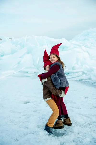 Crianças Sorridentes Bonés Gnomo Vermelho Abraçando Gelo Fundo Inverno — Fotografia de Stock
