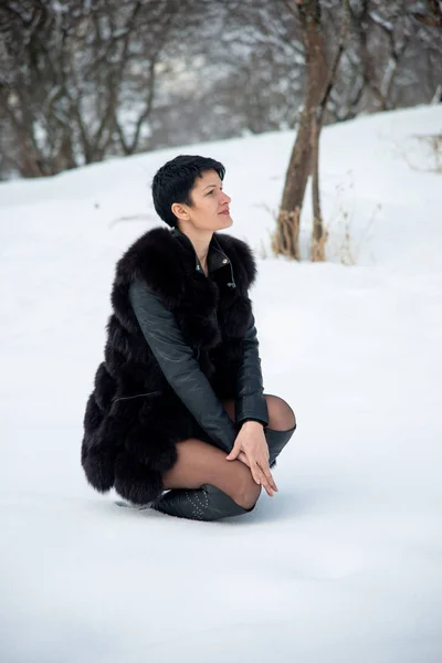 Mulher Elegante Colete Pele Preta Sentado Inverno Fundo Nevado — Fotografia de Stock