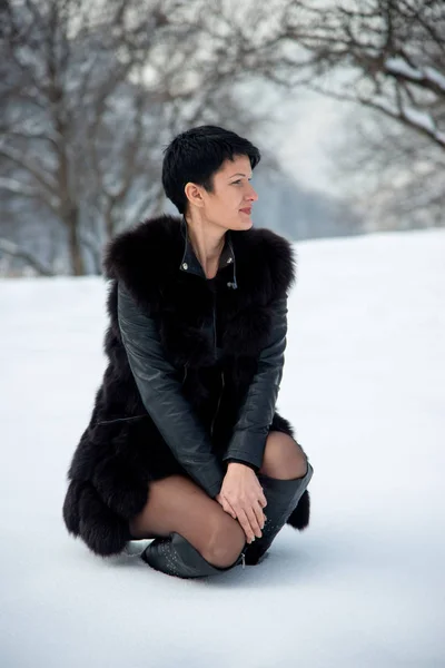 Элегантная Женщина Черном Меховом Жилете Сидит Зимнем Снежном Фоне — стоковое фото