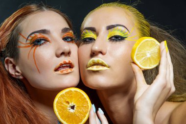 İki genç kız narenciye dilimleri ile
