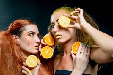İki genç kız narenciye dilimleri ile