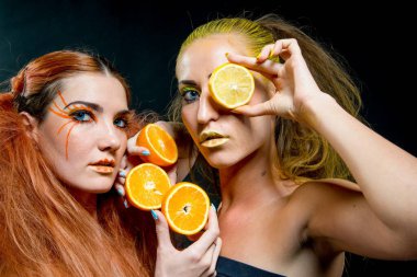 İki genç kız narenciye dilimleri ile