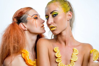 İki genç kız narenciye dilimleri ile