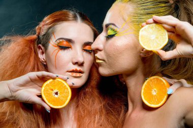 İki genç kız narenciye dilimleri ile