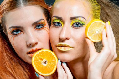 İki genç kız narenciye dilimleri ile