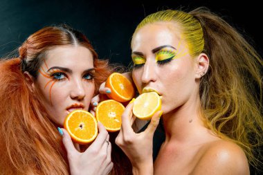 İki genç kız narenciye dilimleri ile