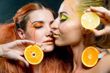 İki genç kız narenciye dilimleri ile