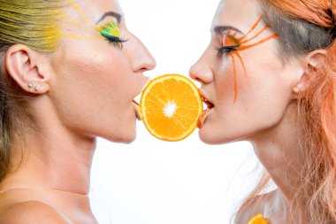 Turunçgil dilimli iki genç kız.