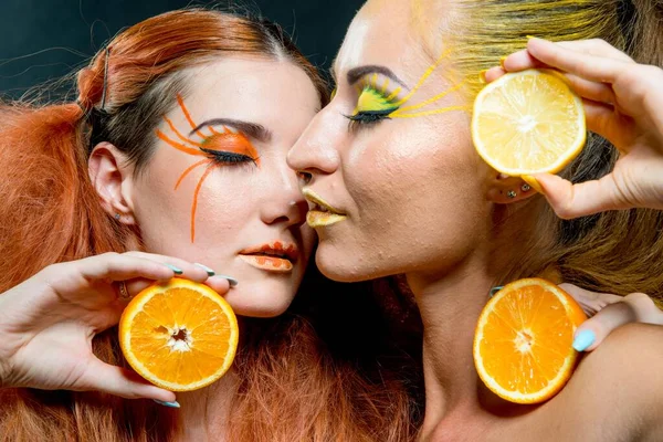İki genç kız narenciye dilimleri ile